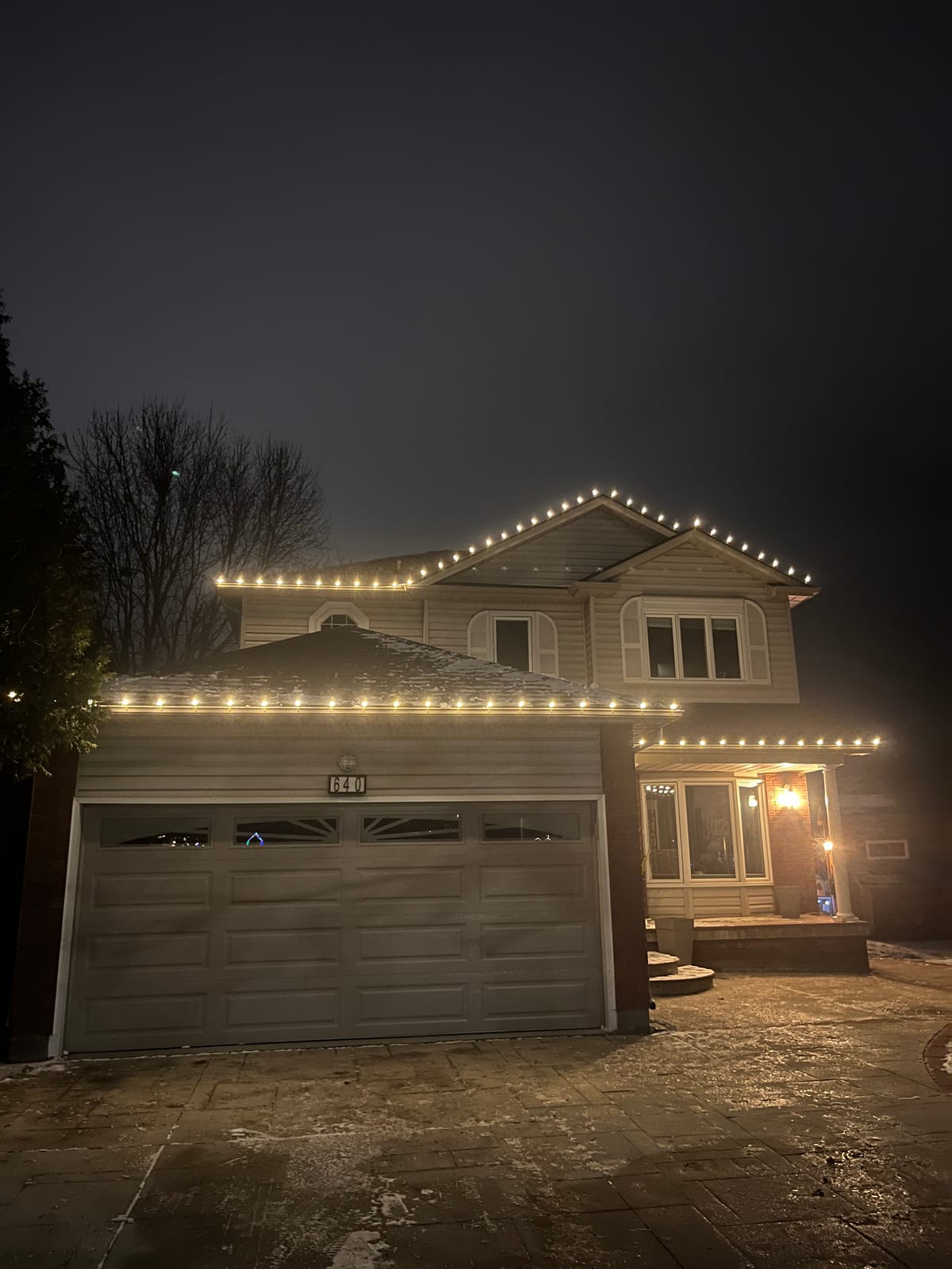 A home with warm-white roofline lighting and an illuminated entrance.